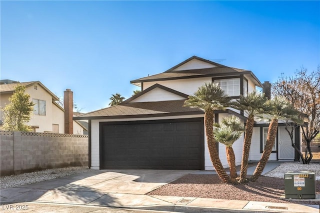 view of front facade featuring a garage, concrete driveway, and fence