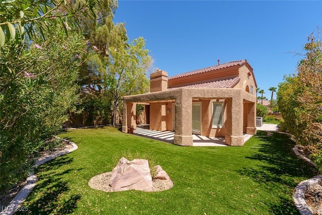 rear view of property with stucco siding, central AC unit, a patio, and a yard