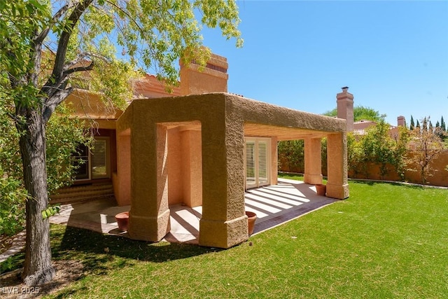 back of property with a yard and a patio area