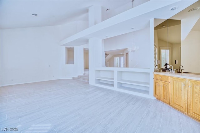 unfurnished room with built in shelves, visible vents, an inviting chandelier, high vaulted ceiling, and stairs