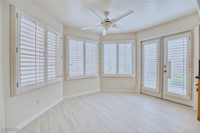 unfurnished sunroom featuring a ceiling fan