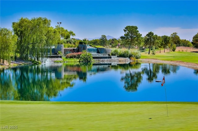 view of property's community with a water view and a lawn