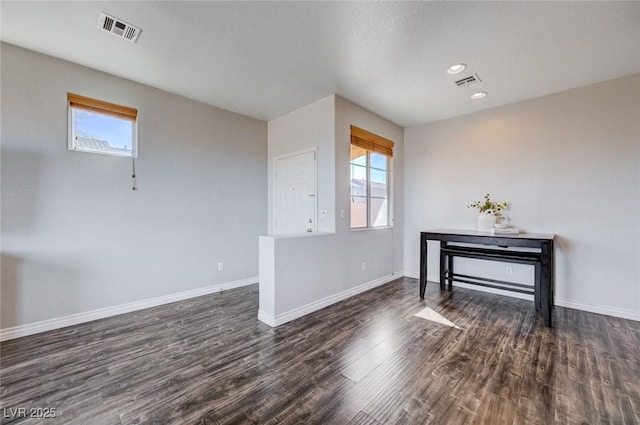 unfurnished room featuring plenty of natural light, visible vents, and baseboards