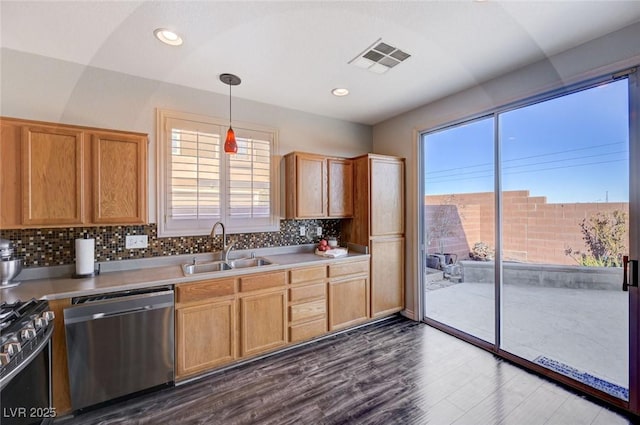 kitchen featuring a sink, visible vents, light countertops, stainless steel dishwasher, and pendant lighting