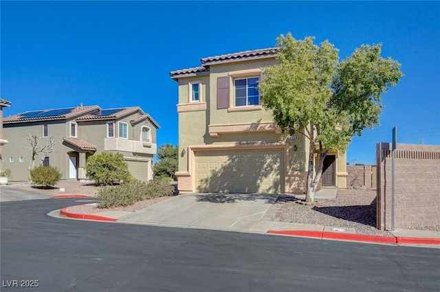 mediterranean / spanish-style house with solar panels, stucco siding, an attached garage, fence, and driveway