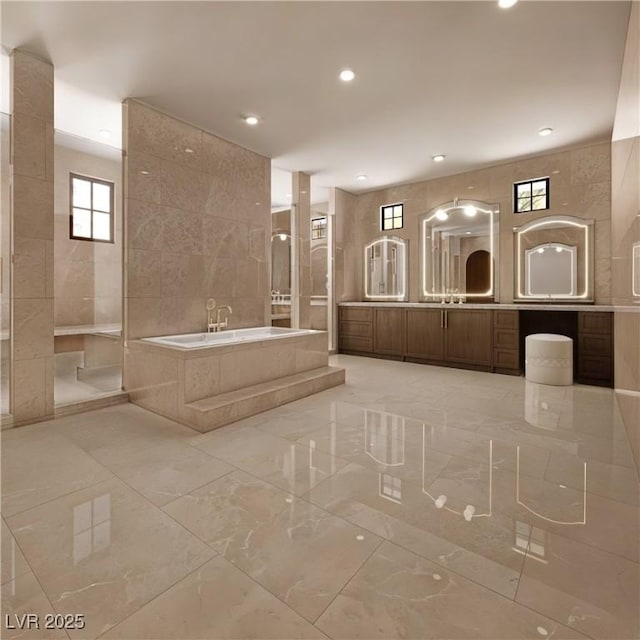 full bath featuring a garden tub, recessed lighting, marble finish floor, and vanity