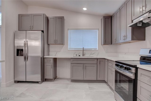 kitchen with lofted ceiling, under cabinet range hood, stainless steel appliances, a sink, and gray cabinets