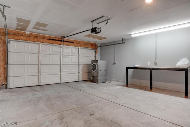 garage with a garage door opener, washer / clothes dryer, and baseboards