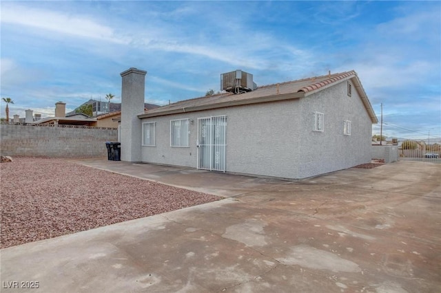 back of house featuring a patio, stucco siding, fence, and central air condition unit