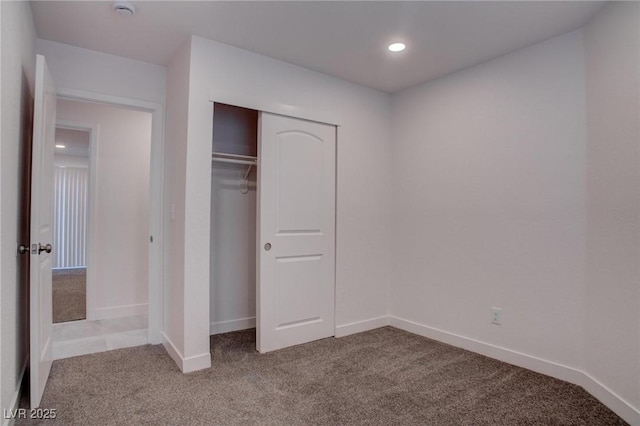 unfurnished bedroom featuring baseboards, a closet, recessed lighting, and light colored carpet