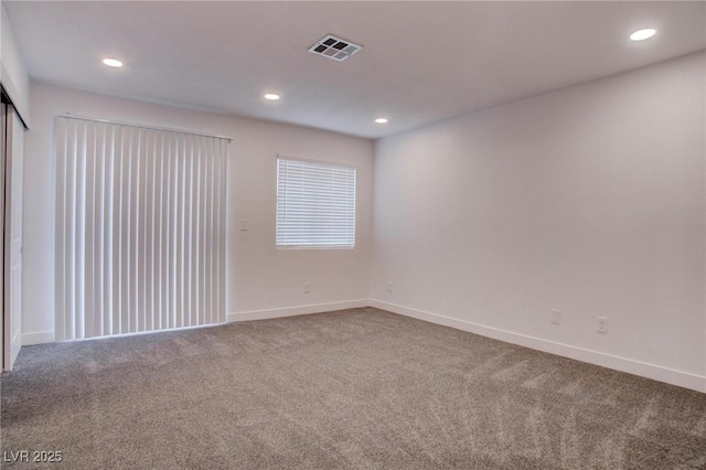 carpeted spare room featuring baseboards, visible vents, and recessed lighting