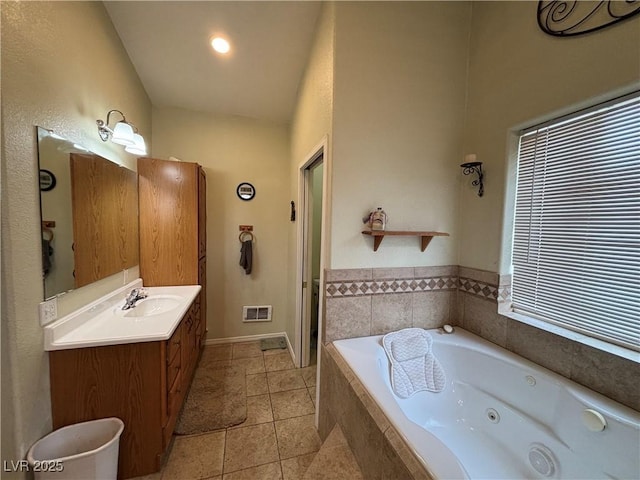 full bathroom with tile patterned flooring, visible vents, baseboards, a whirlpool tub, and vanity
