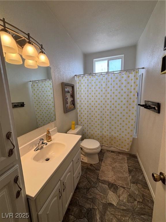 bathroom with toilet, curtained shower, a textured ceiling, vanity, and a textured wall
