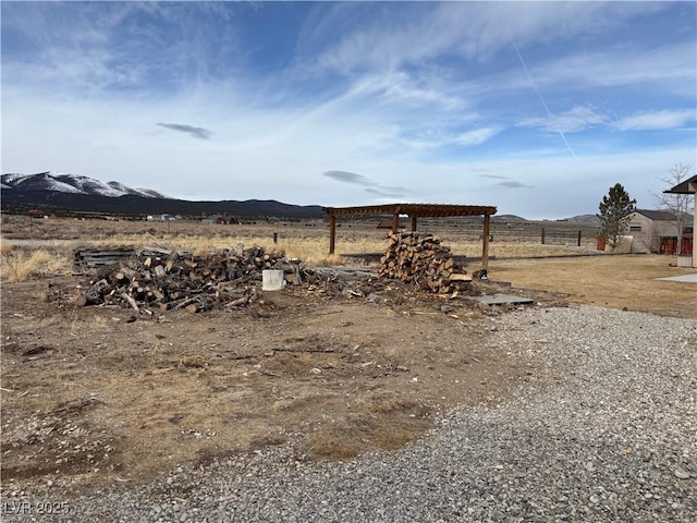 view of yard featuring fence, a rural view, and a mountain view