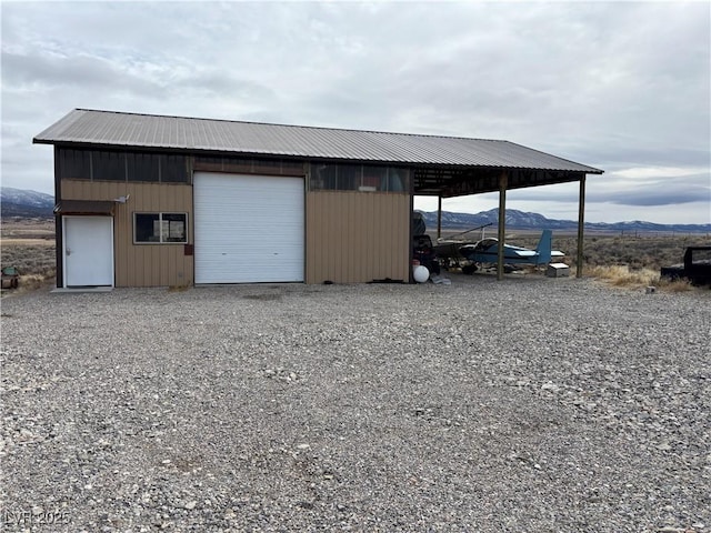 view of outbuilding featuring a mountain view, an outbuilding, and gravel driveway