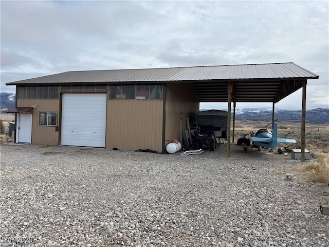 view of outbuilding with an outbuilding, a mountain view, and driveway