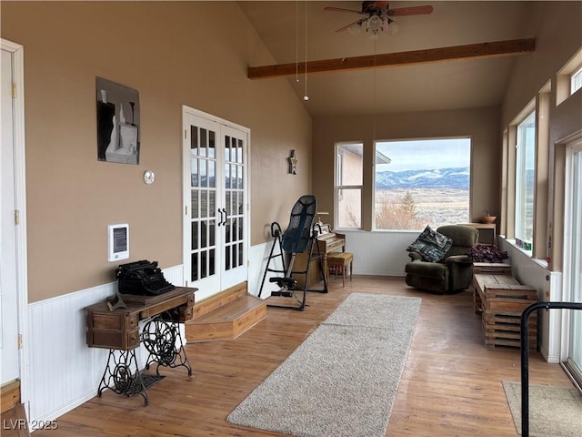 sunroom featuring visible vents, a ceiling fan, french doors, a mountain view, and vaulted ceiling with beams