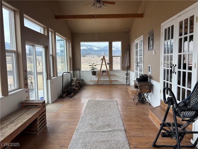 sunroom / solarium featuring a mountain view, lofted ceiling with beams, and ceiling fan