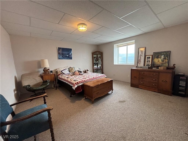 bedroom with light carpet and a drop ceiling