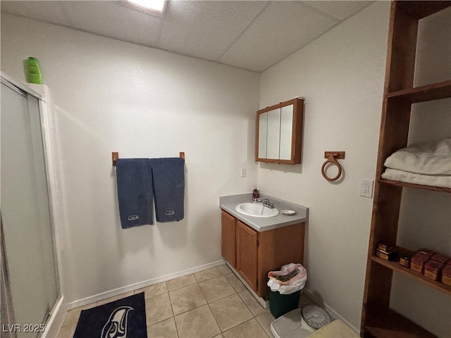 full bath with vanity, baseboards, tile patterned flooring, a shower stall, and a paneled ceiling