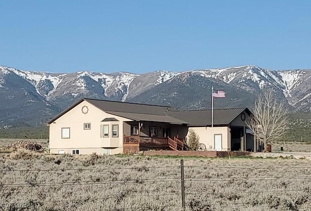 rear view of house with a mountain view and a porch