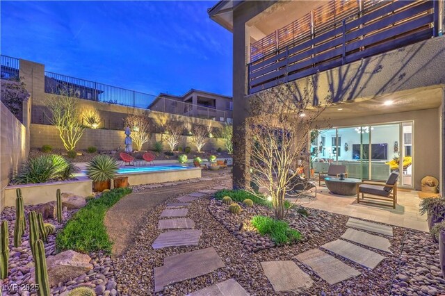 yard at dusk featuring a patio, a fenced backyard, and a fenced in pool