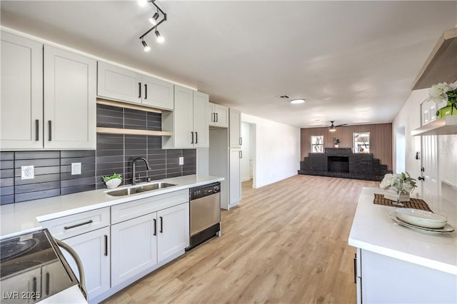 kitchen featuring light countertops, appliances with stainless steel finishes, a sink, and white cabinets