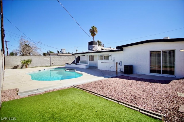 rear view of house featuring a patio area, a fenced backyard, central AC, and stucco siding