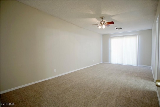 empty room with visible vents, baseboards, ceiling fan, a textured ceiling, and carpet floors