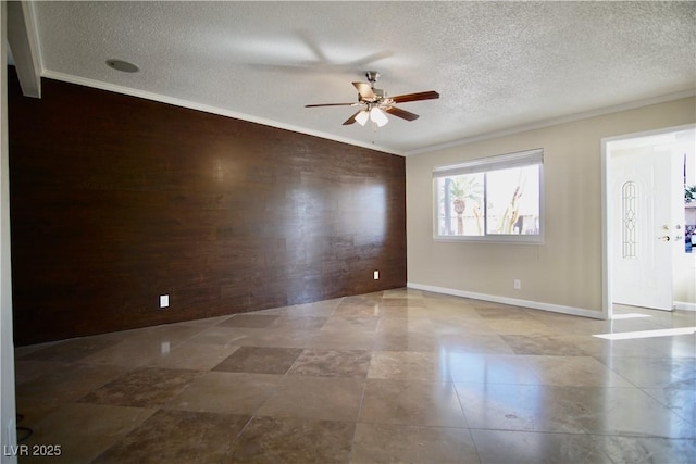 spare room with ornamental molding, ceiling fan, a textured ceiling, and baseboards