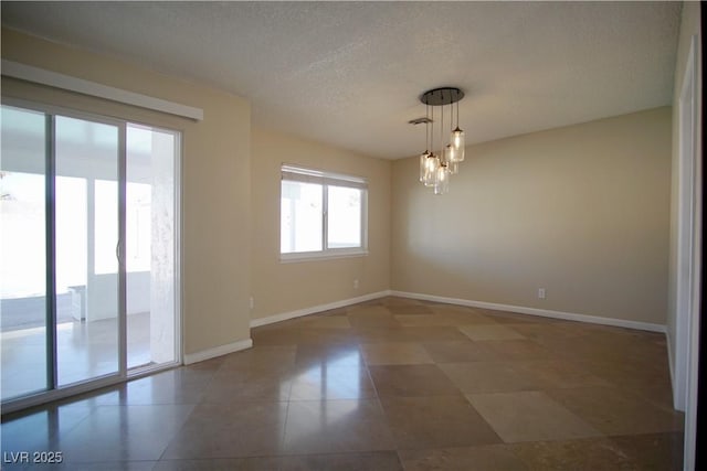 empty room with a textured ceiling, baseboards, and a notable chandelier