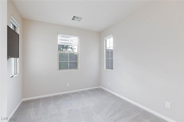 empty room featuring baseboards, visible vents, and carpet flooring