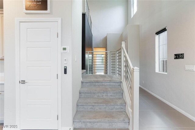 stairs featuring tile patterned flooring and baseboards