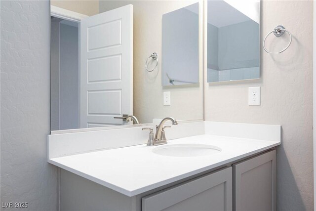 bathroom with a textured wall and vanity