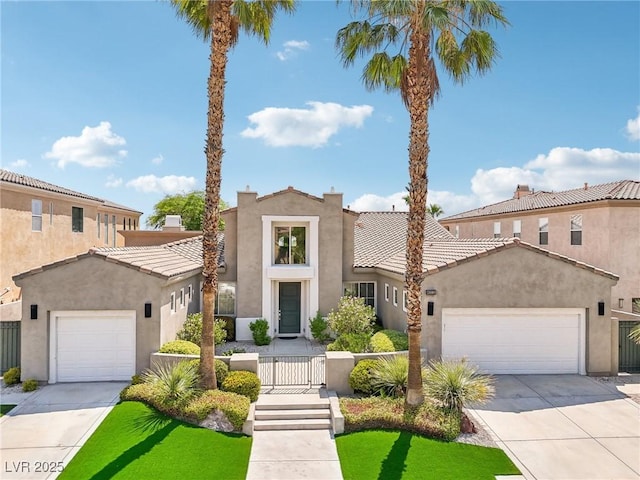 mediterranean / spanish-style home featuring concrete driveway, an attached garage, a tiled roof, and stucco siding