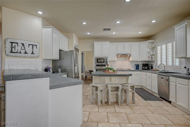 kitchen with open shelves, stainless steel appliances, visible vents, white cabinets, and under cabinet range hood