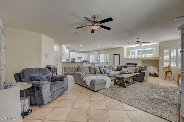 living room with light tile patterned floors, ceiling fan, visible vents, and recessed lighting