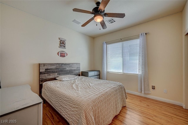 bedroom featuring a ceiling fan, light wood-style flooring, visible vents, and baseboards