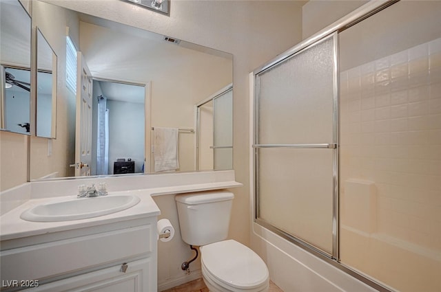 bathroom with ceiling fan, toilet, shower / bath combination with glass door, visible vents, and vanity