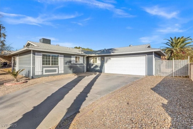 ranch-style house featuring a garage, concrete driveway, and fence