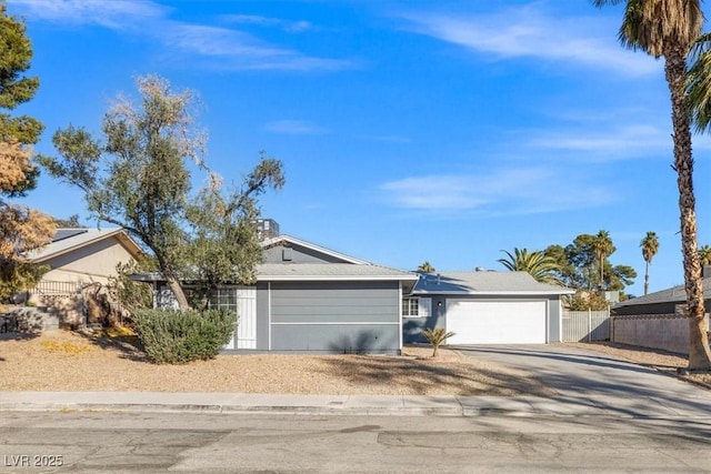 ranch-style house with fence, driveway, and an attached garage