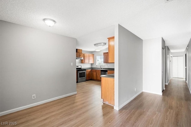 kitchen featuring appliances with stainless steel finishes, under cabinet range hood, light wood-style flooring, and baseboards