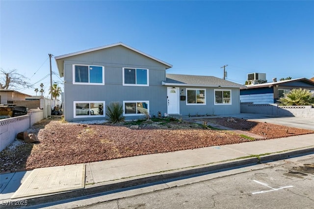 tri-level home with central AC, fence, and driveway