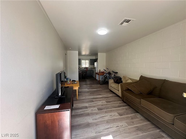 living area featuring visible vents and wood finished floors