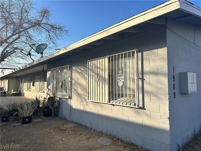 view of side of property with concrete block siding and a patio