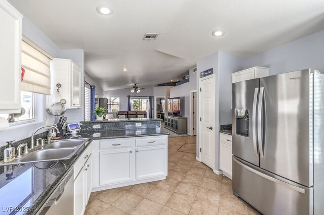 kitchen with a peninsula, a sink, visible vents, white cabinets, and appliances with stainless steel finishes