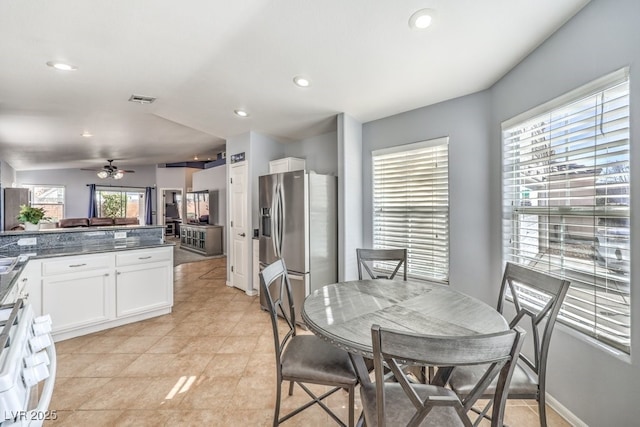 kitchen with white cabinets, dark countertops, visible vents, and stainless steel fridge with ice dispenser