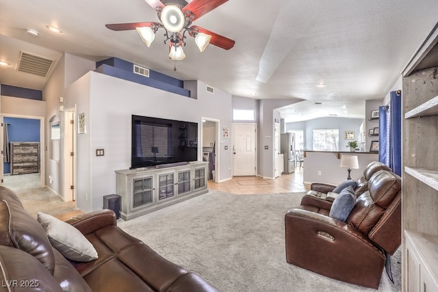 living area with light carpet, visible vents, and lofted ceiling