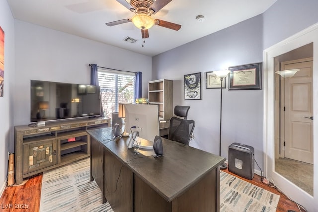 home office with ceiling fan, light wood finished floors, and visible vents