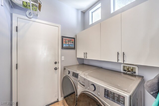 laundry room featuring light tile patterned floors, washer and clothes dryer, and cabinet space